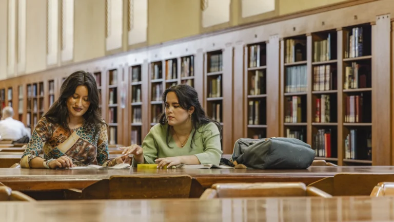 Two students reading at the library.
